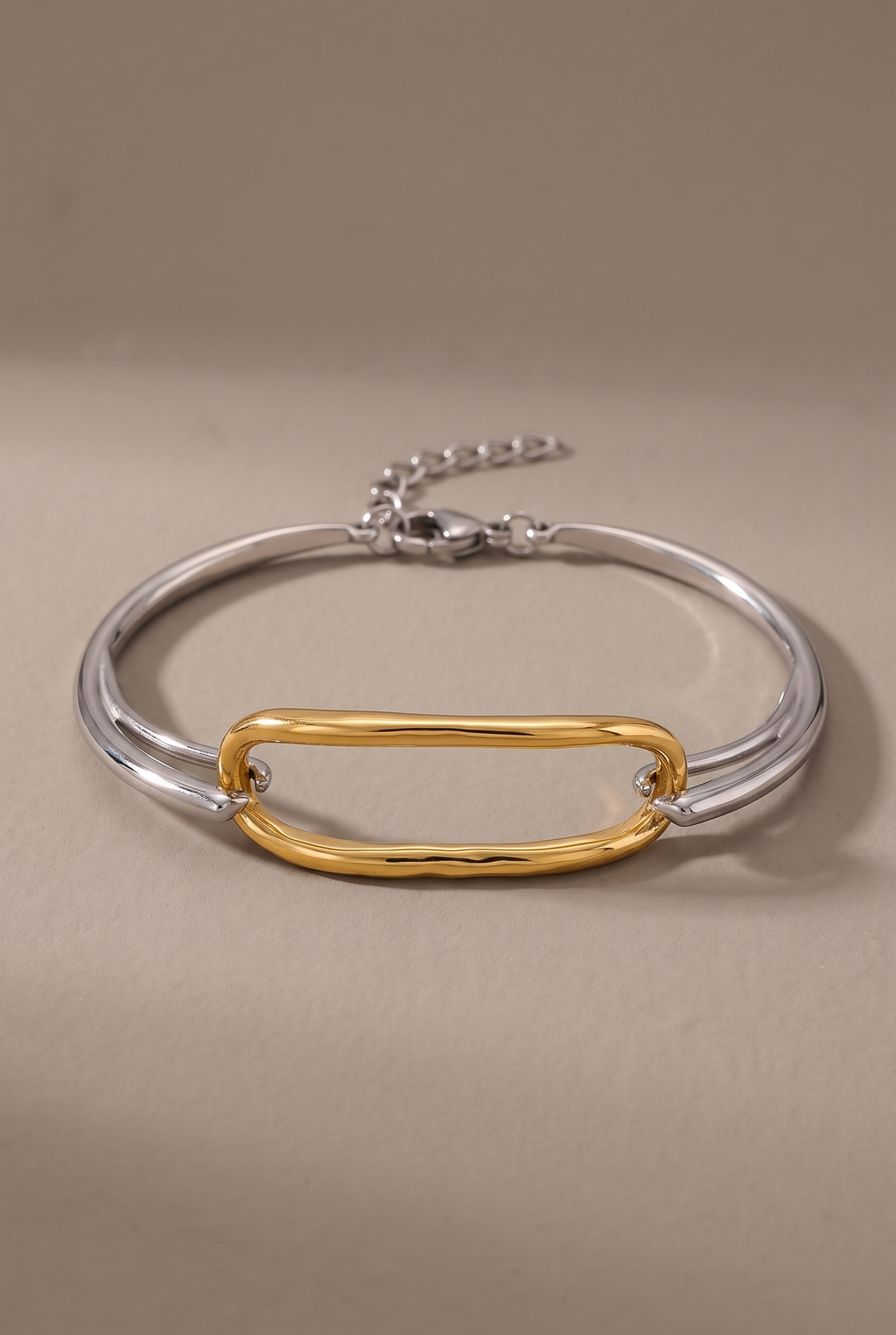 DropIQ two-tone bracelet with a gold oval link on a slim silver band