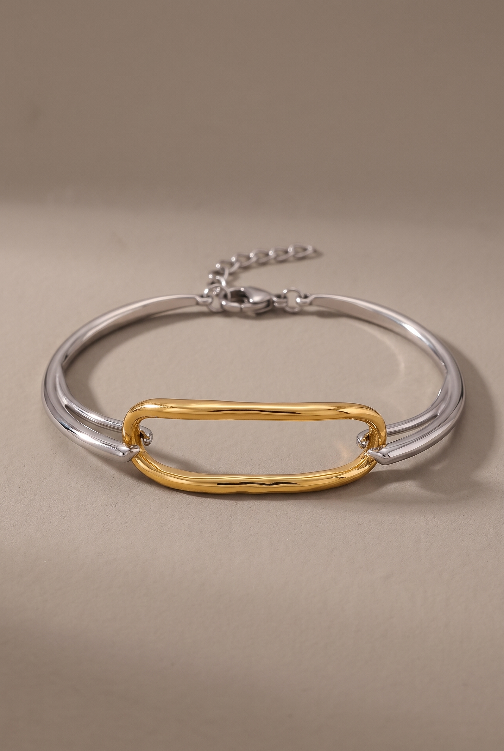 DropIQ two-tone bracelet with a gold oval link on a slim silver band
