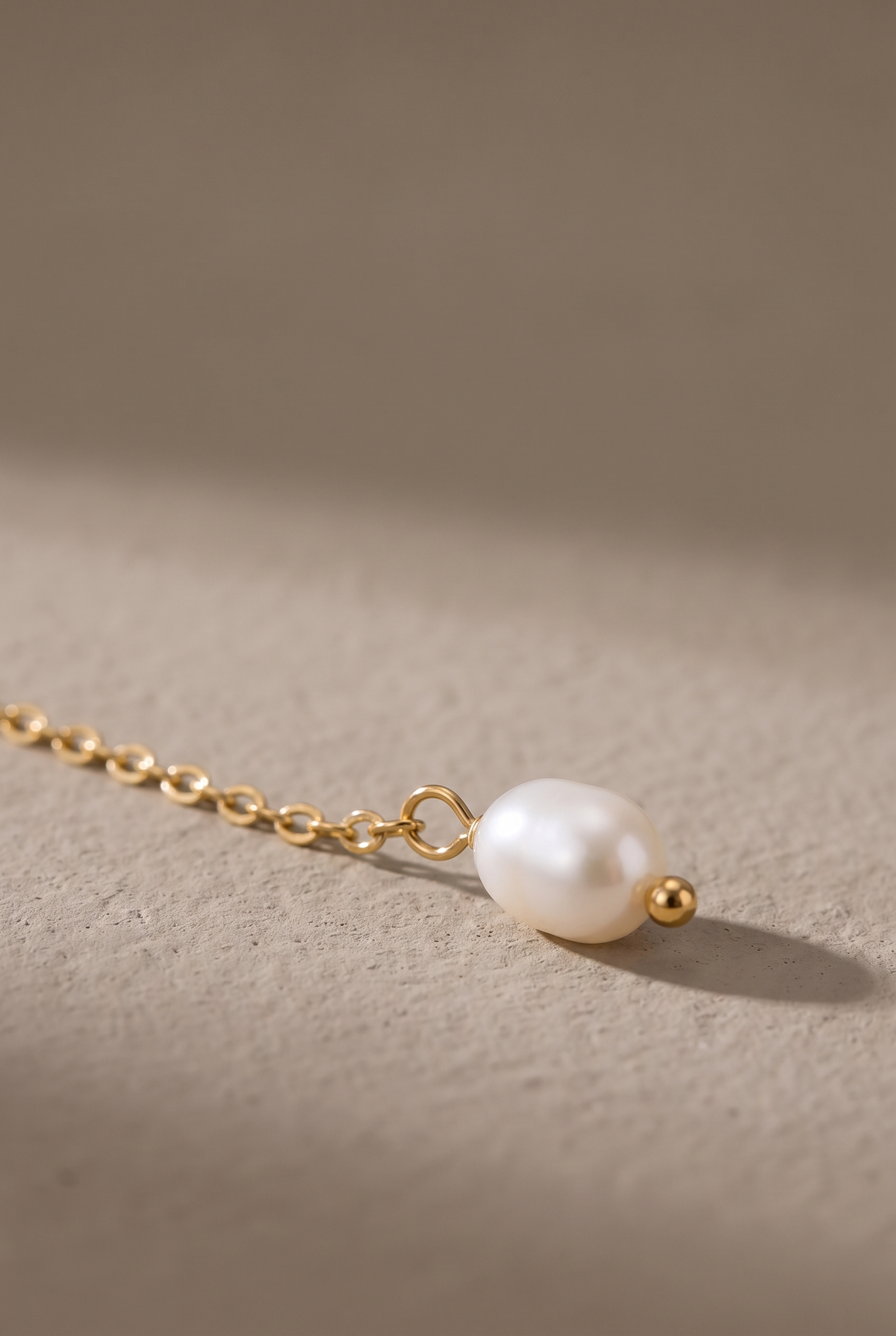 Close-up of the pearl drop and ball bead on the fine chain